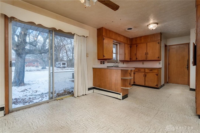 kitchen featuring a textured ceiling, a baseboard radiator, kitchen peninsula, and ceiling fan