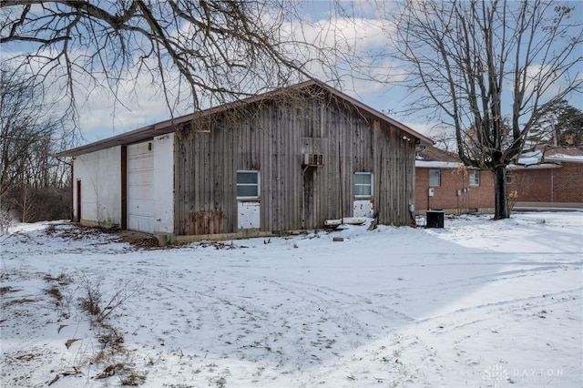 snow covered structure featuring a garage