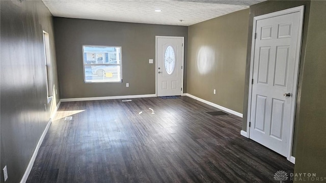 entryway with dark hardwood / wood-style flooring and a textured ceiling