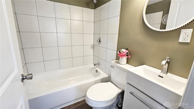 full bathroom featuring vanity, tiled shower / bath, and toilet