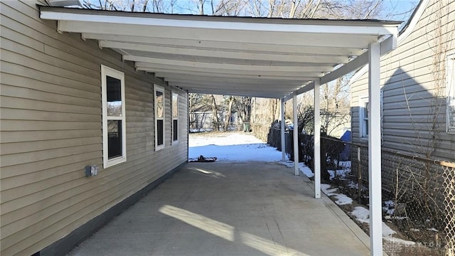 snow covered patio with a carport