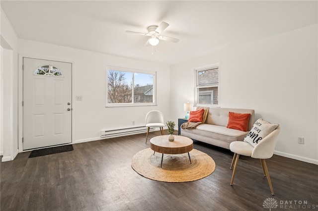 living room with dark hardwood / wood-style flooring, a baseboard heating unit, and ceiling fan