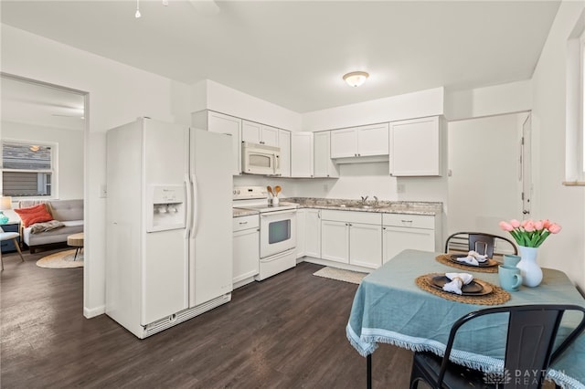 kitchen with sink, white appliances, dark wood-type flooring, and white cabinets