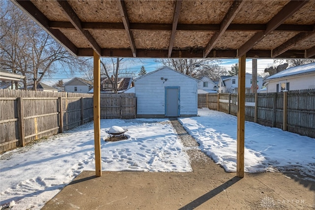 snow covered patio featuring a shed