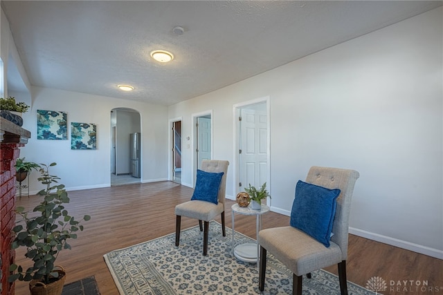 sitting room with dark wood-type flooring and a textured ceiling