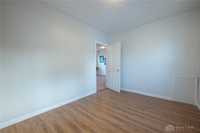 unfurnished room featuring hardwood / wood-style floors and a textured ceiling