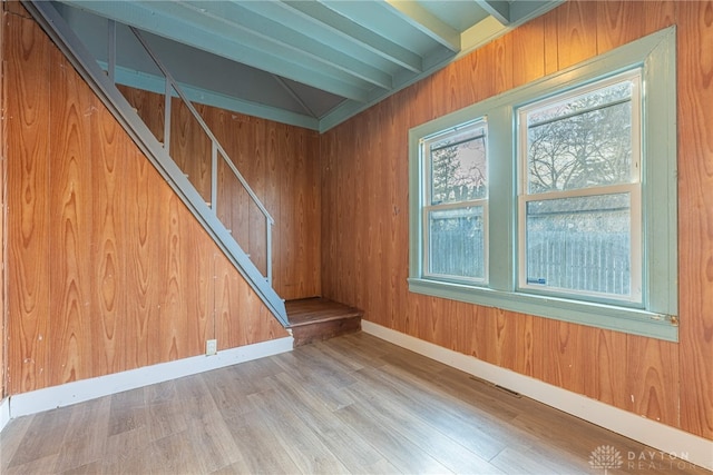 unfurnished room featuring beamed ceiling and hardwood / wood-style floors