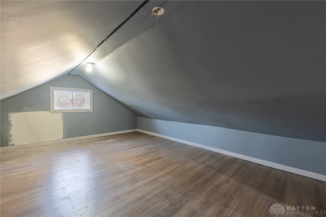 additional living space with wood-type flooring and lofted ceiling