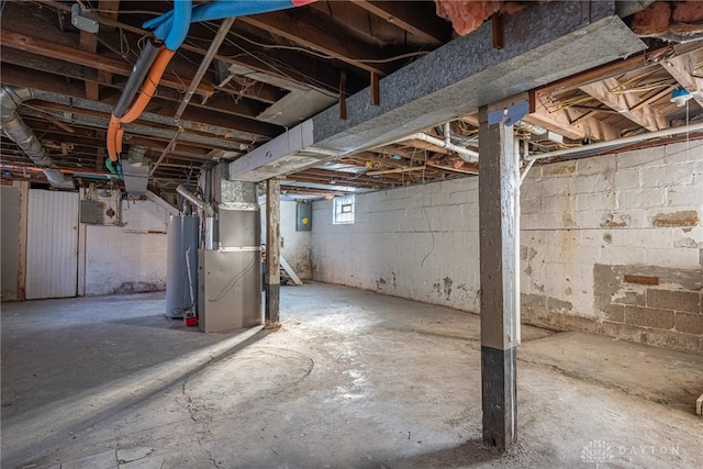 basement with heating unit, gas water heater, and electric panel