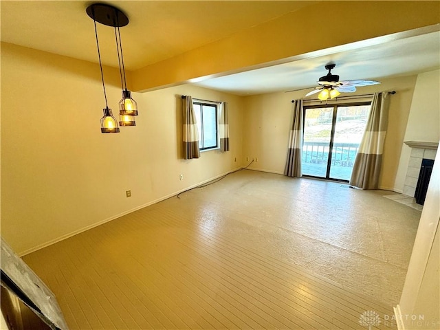 unfurnished living room with ceiling fan and a fireplace