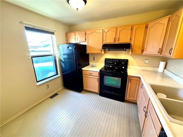 kitchen with sink, light brown cabinets, and black appliances