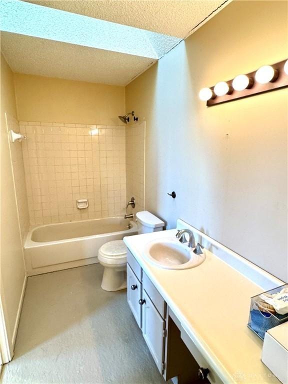 full bathroom featuring tiled shower / bath, vanity, a textured ceiling, and toilet