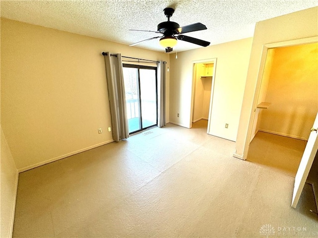 empty room with ceiling fan and a textured ceiling