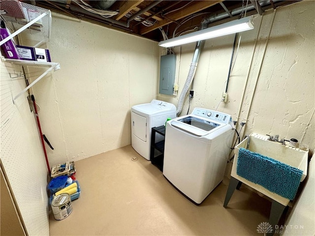 clothes washing area featuring electric panel and washing machine and dryer