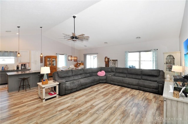 living room with vaulted ceiling, sink, ceiling fan, and light wood-type flooring