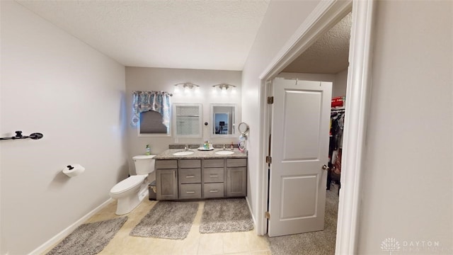 bathroom with vanity, a textured ceiling, and toilet