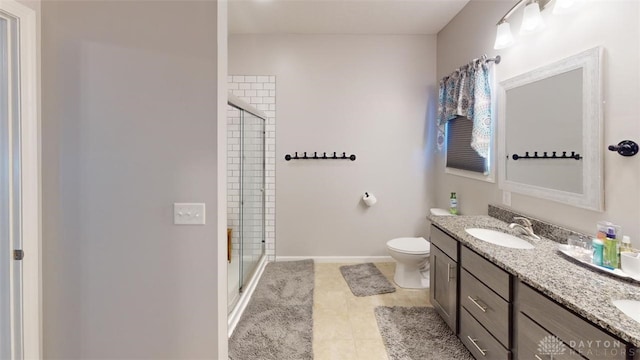 bathroom featuring vanity, toilet, a shower with shower door, and tile patterned flooring