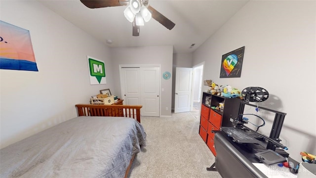 carpeted bedroom with ceiling fan and a closet