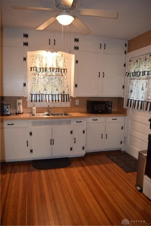 bar featuring sink, ceiling fan, white cabinets, and light wood-type flooring