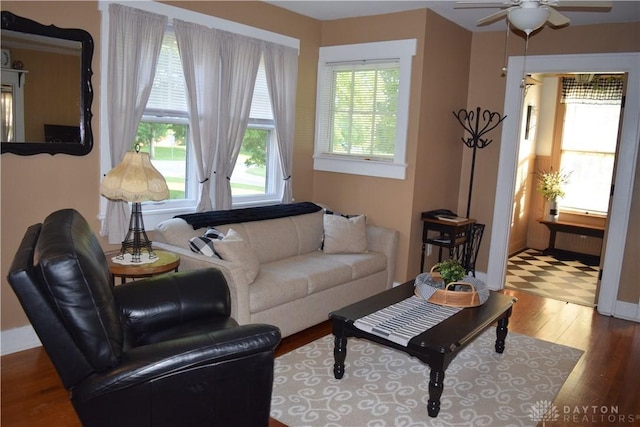 living room featuring wood finished floors, baseboards, and ceiling fan
