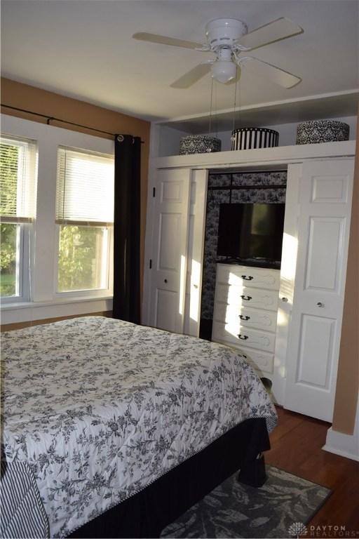 bedroom featuring dark hardwood / wood-style floors, ceiling fan, and a closet