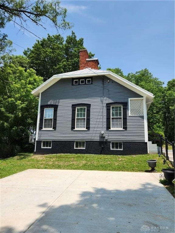 2282 Whitey Marshall Dr, Beavercreek, OH 45434 - view of side of property featuring a yard, a chimney, and a patio