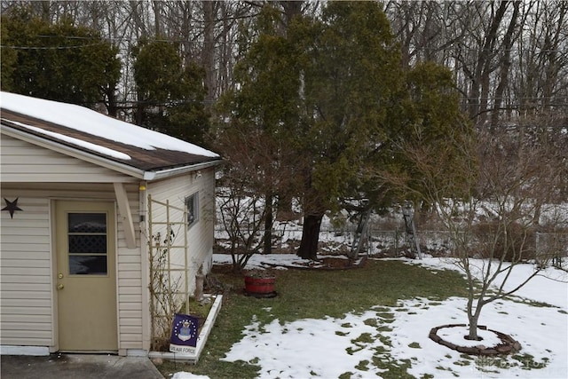 snowy yard featuring a storage shed