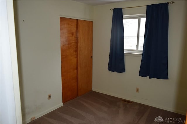 unfurnished bedroom with a closet and carpet