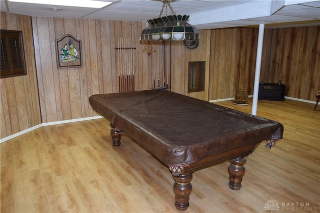 rec room featuring light wood-type flooring, a paneled ceiling, wooden walls, and billiards