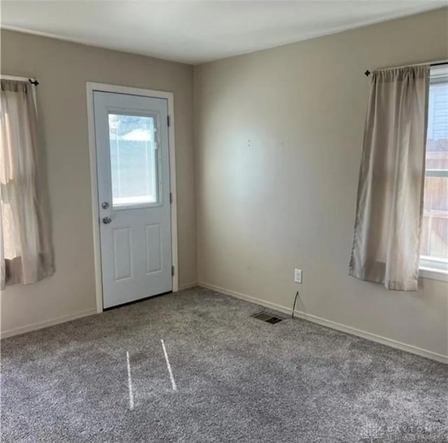 entryway with plenty of natural light and light colored carpet