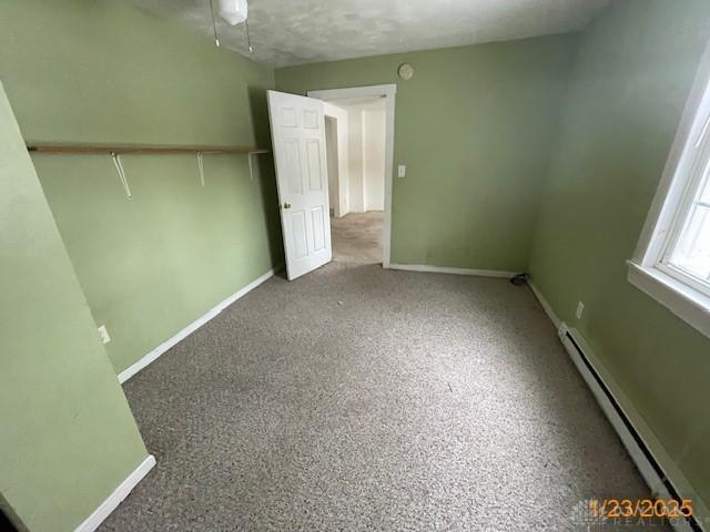 unfurnished bedroom featuring baseboard heating