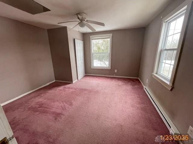 carpeted spare room featuring ceiling fan, a baseboard radiator, and plenty of natural light