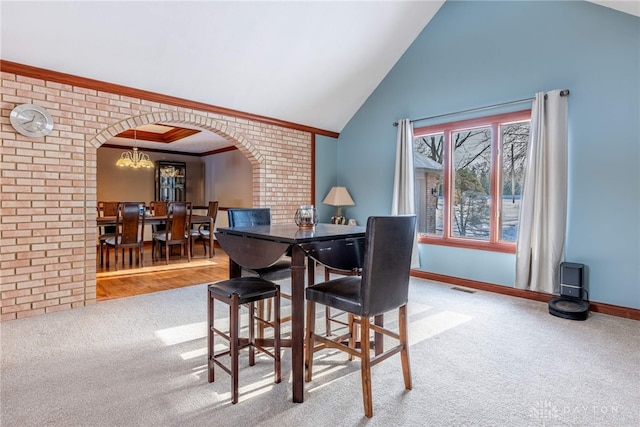 dining room featuring crown molding, carpet, lofted ceiling, and an inviting chandelier