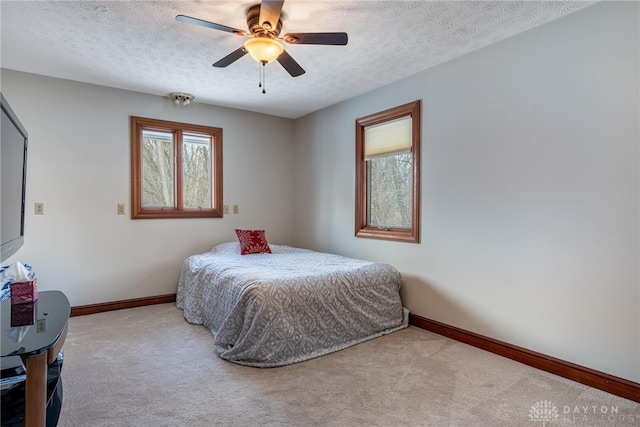 carpeted bedroom with a textured ceiling and ceiling fan