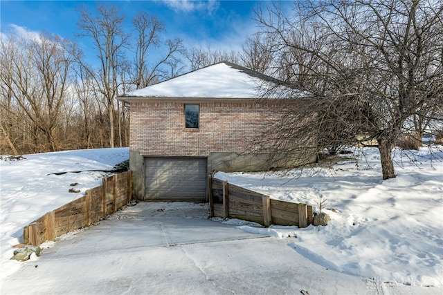 view of snowy exterior featuring a garage