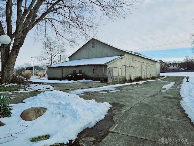 view of snow covered exterior with an outdoor structure