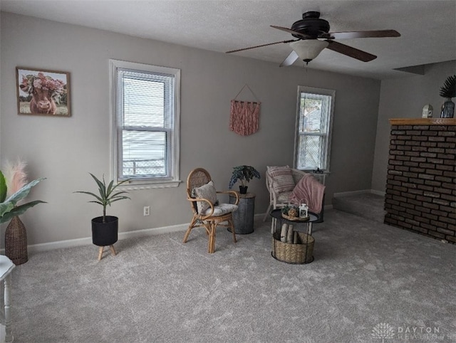 sitting room featuring ceiling fan, light colored carpet, and a textured ceiling