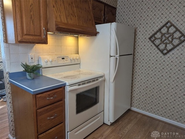 kitchen with white range with electric cooktop, hardwood / wood-style floors, custom exhaust hood, and backsplash