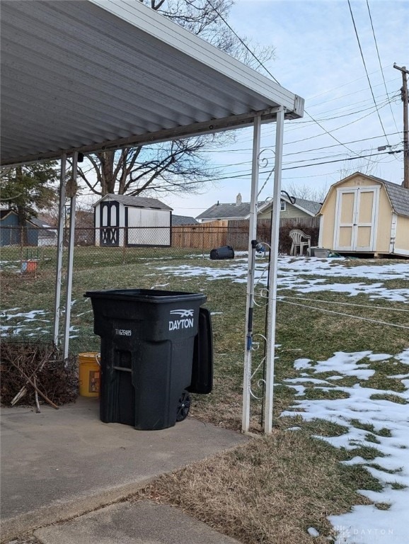 yard layered in snow with a storage unit