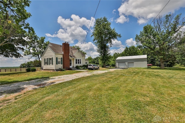 view of side of property with an outbuilding, a yard, a detached garage, and fence