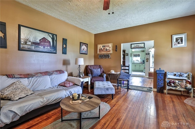 living area featuring wood-type flooring and a textured ceiling