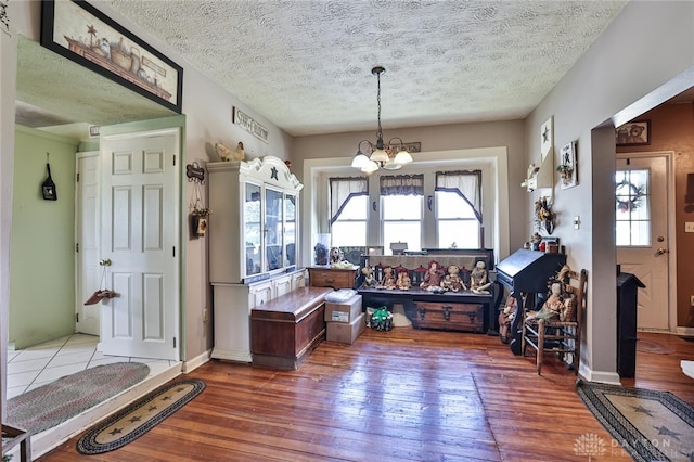 dining area featuring a textured ceiling, wood-type flooring, and an inviting chandelier