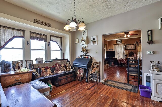 dining room featuring a textured ceiling, hardwood / wood-style floors, and ceiling fan with notable chandelier