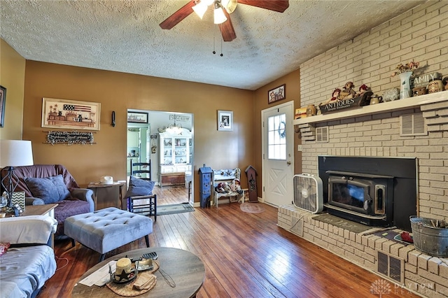 living room featuring a textured ceiling, ceiling fan, visible vents, and hardwood / wood-style flooring