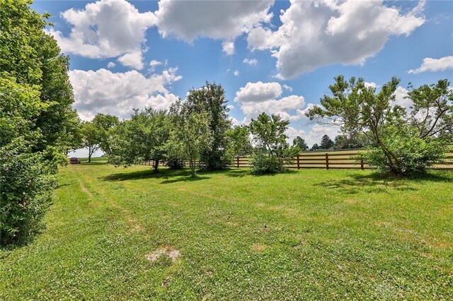 view of yard featuring fence and a rural view