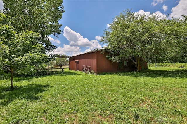 view of yard with fence, an outdoor structure, and an outbuilding