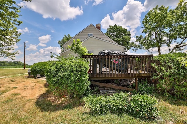 back of property featuring a chimney and a deck