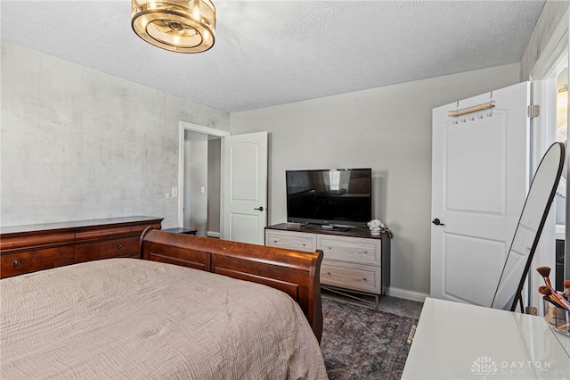 bedroom featuring baseboards and a textured ceiling