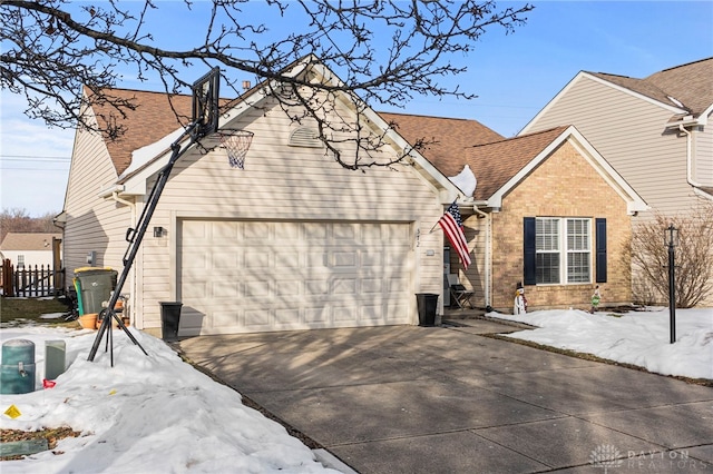 exterior space featuring driveway, brick siding, roof with shingles, and an attached garage