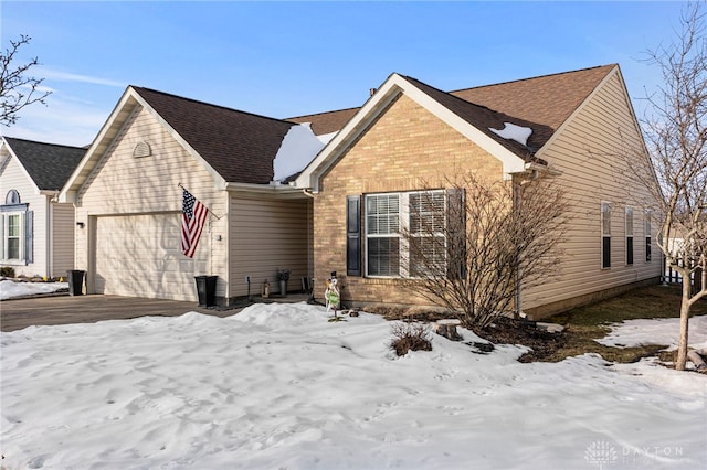 view of front of house with a garage, roof with shingles, aphalt driveway, and brick siding